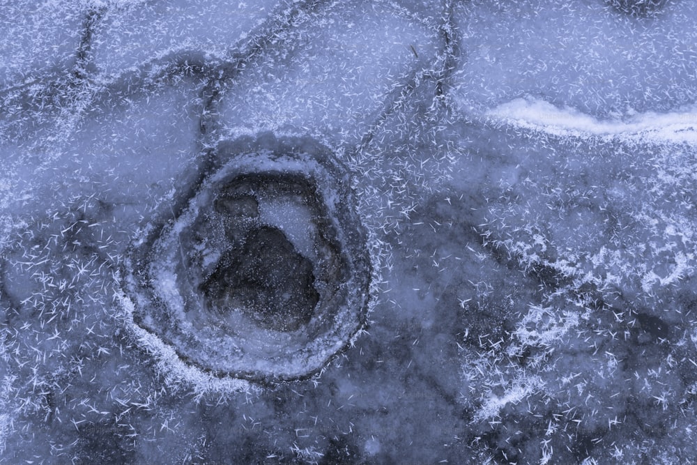 a small hole in the ice that looks like a hole in the ground
