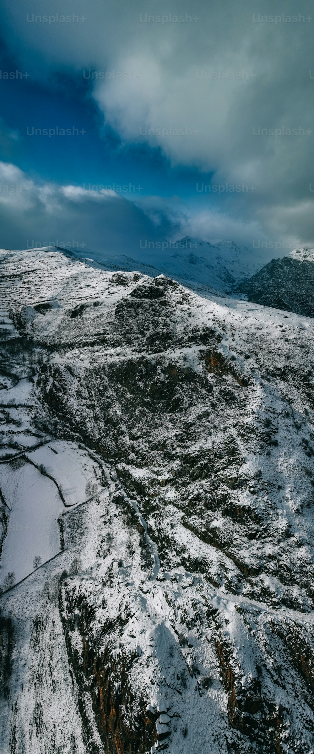 a snow covered mountain with a cloudy sky