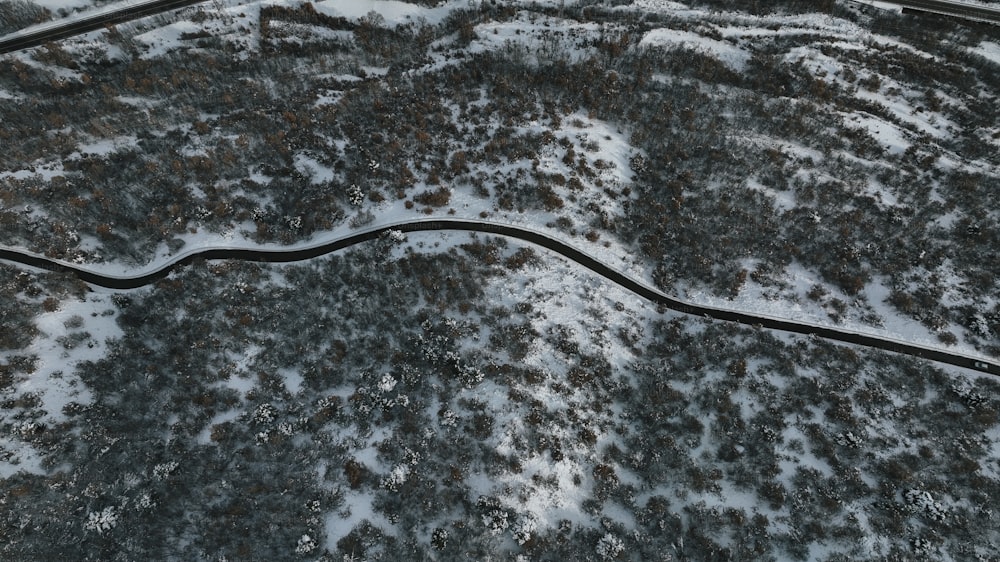 an aerial view of a winding road in the snow