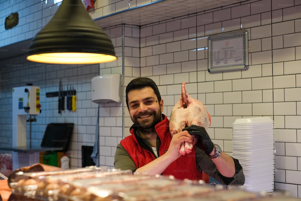 a man holding up a piece of meat in a kitchen