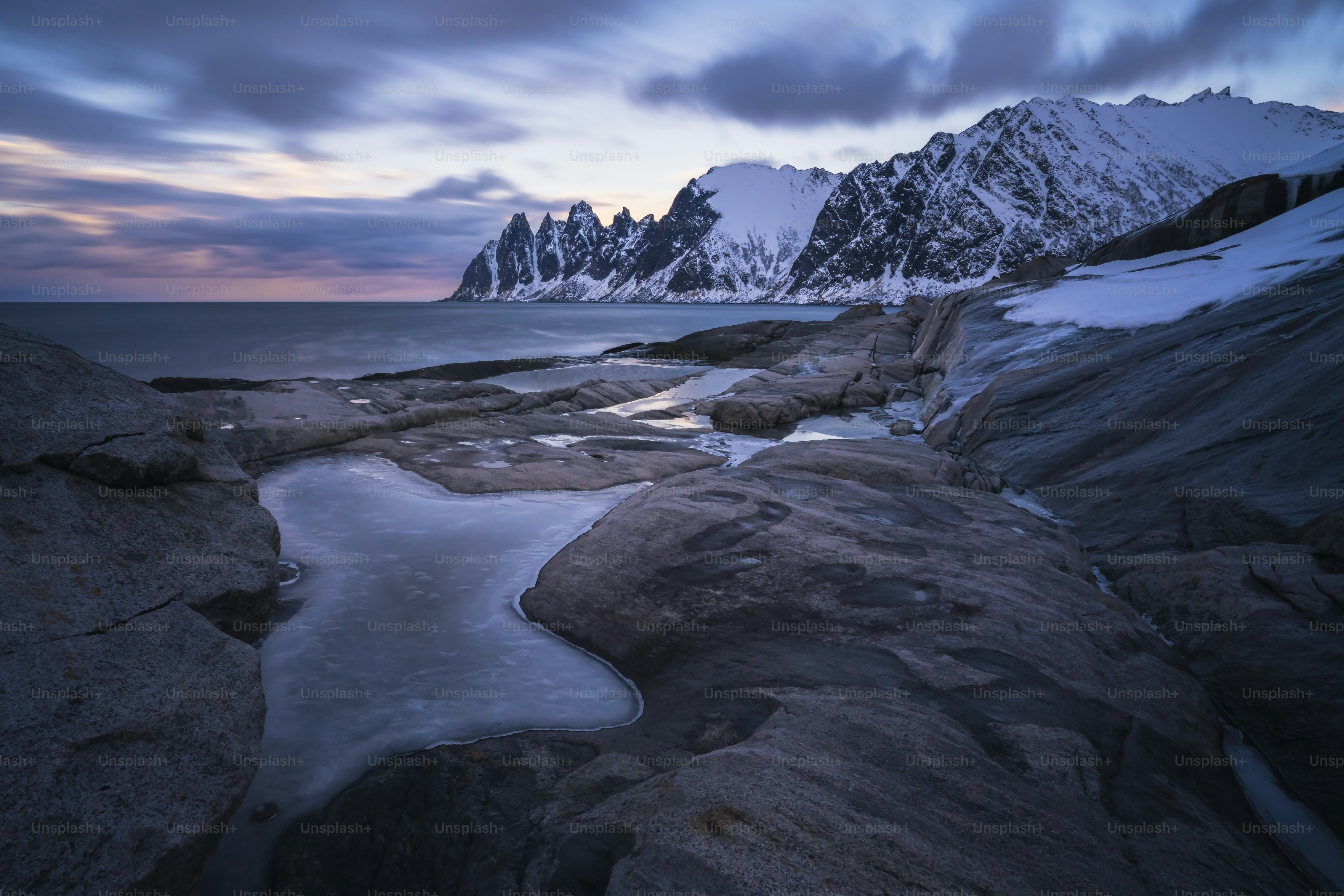a mountain range with a body of water in the foreground