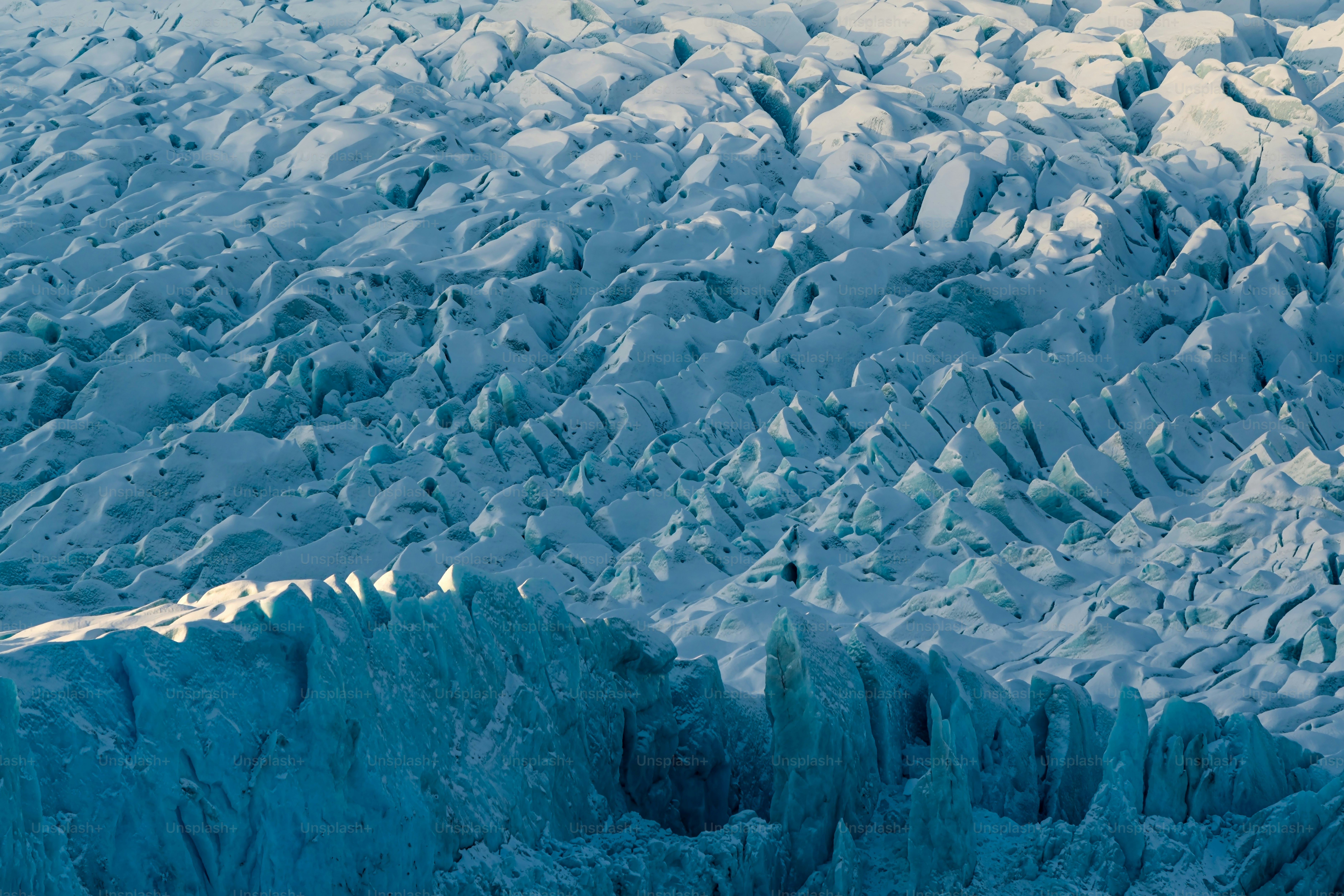 an airplane flying over a large ice covered mountain