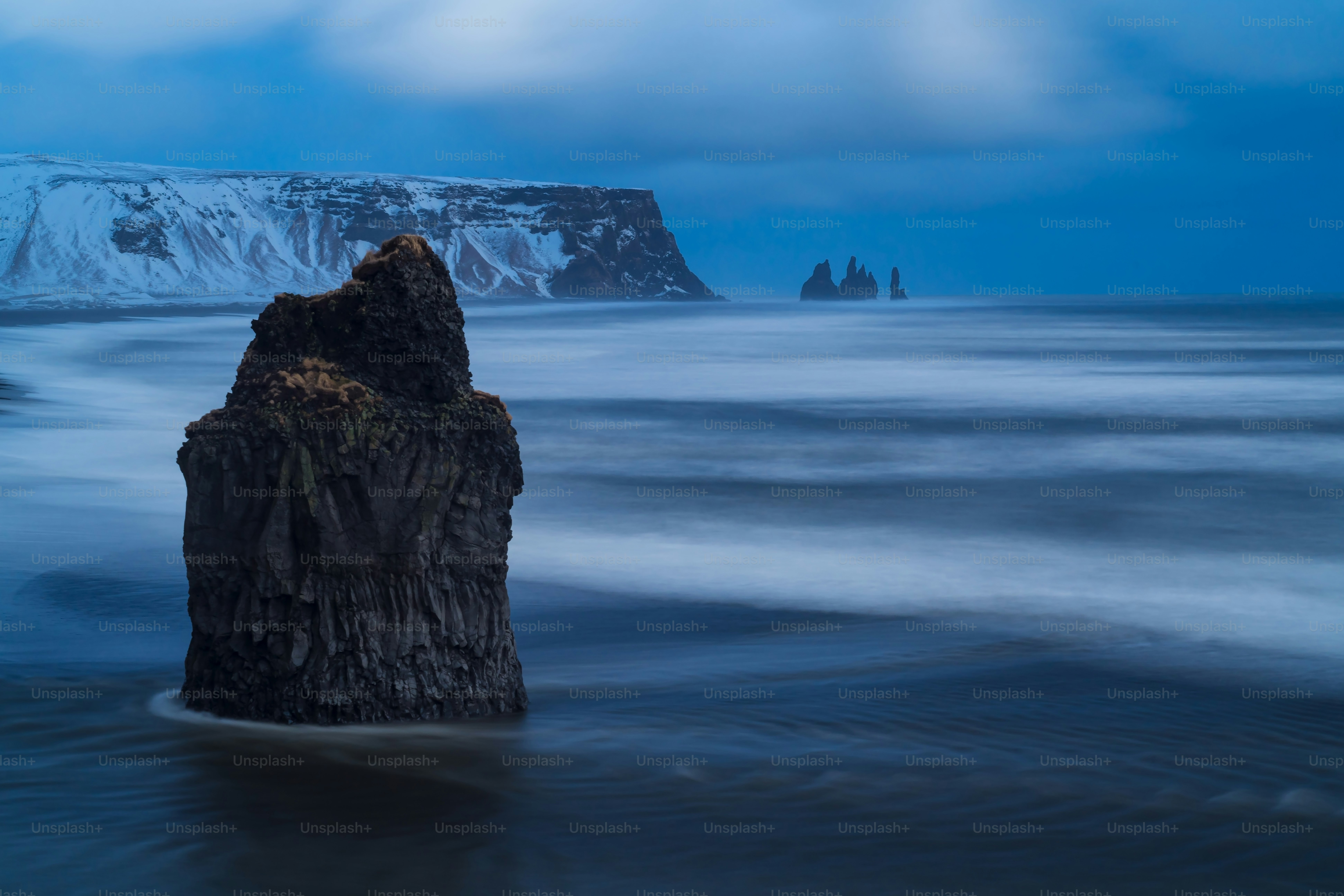 a large rock sticking out of the ocean
