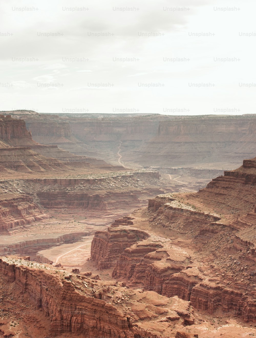 Un uomo in piedi sulla cima di una scogliera che domina un canyon
