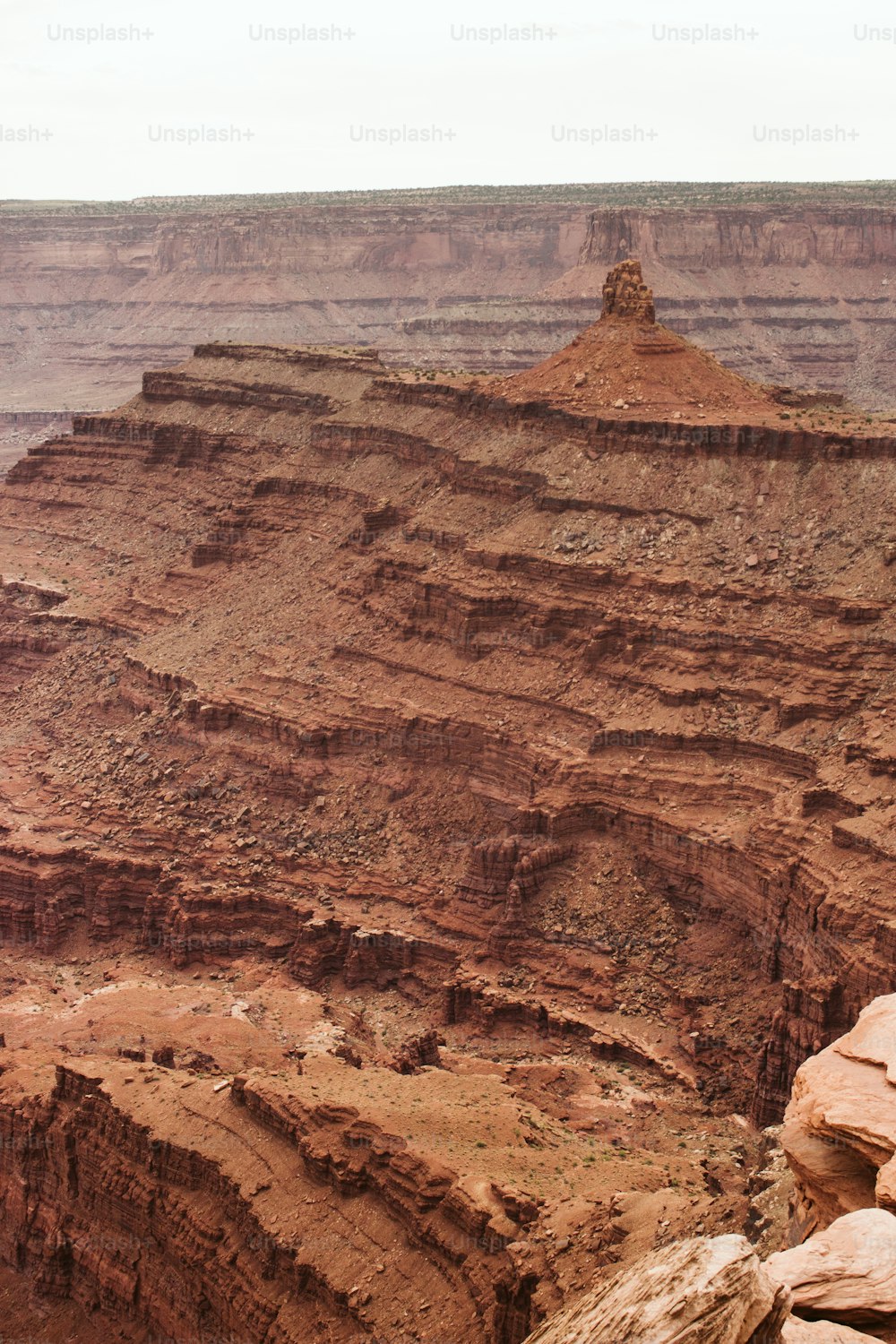 Un homme assis sur un rocher surplombant un canyon