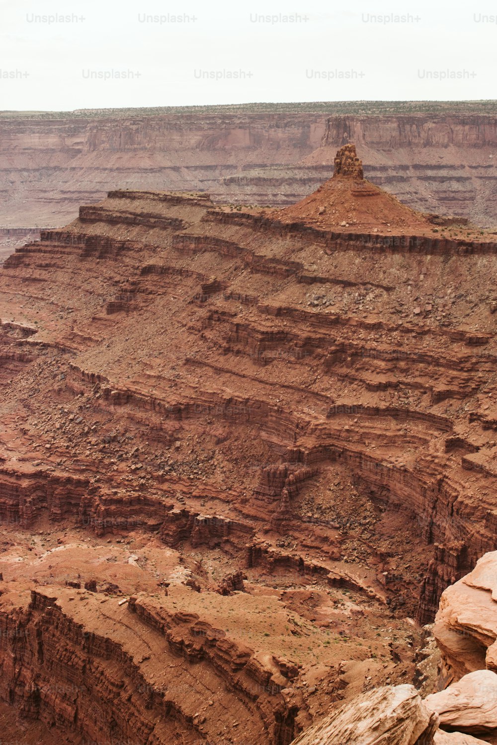 a man sitting on a rock overlooking a canyon