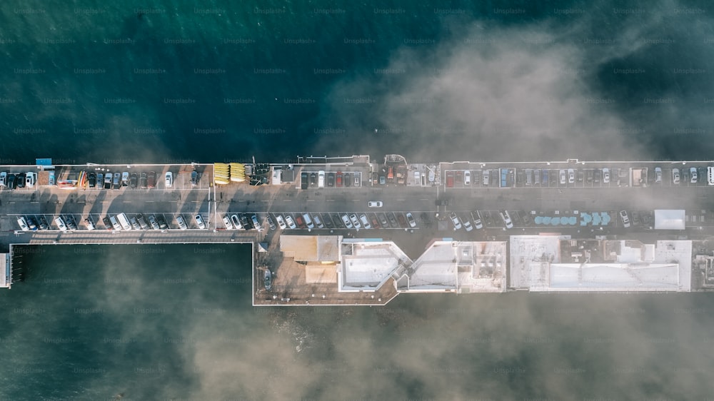 an aerial view of a pier with cars parked on it