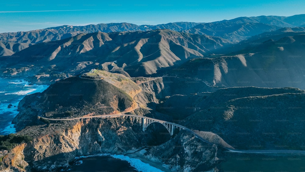 an aerial view of a road winding through a mountain range