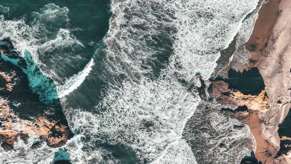 uma vista aérea de uma praia com ondas batendo na costa
