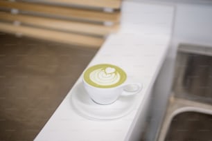 a cup of coffee sitting on top of a white counter