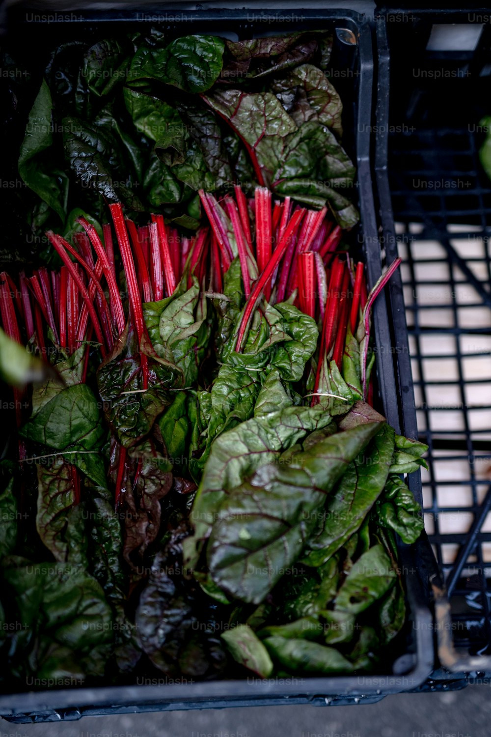 a basket filled with lots of green and red vegetables