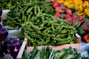 a pile of green peppers sitting on top of a table