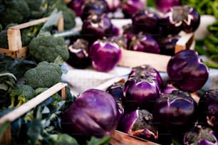 purple onions and broccoli are on display at a market