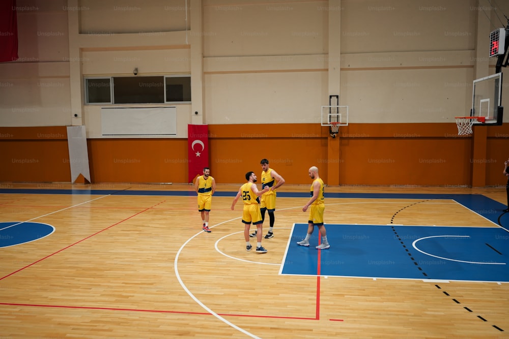 um grupo de homens em pé em cima de uma quadra de basquete