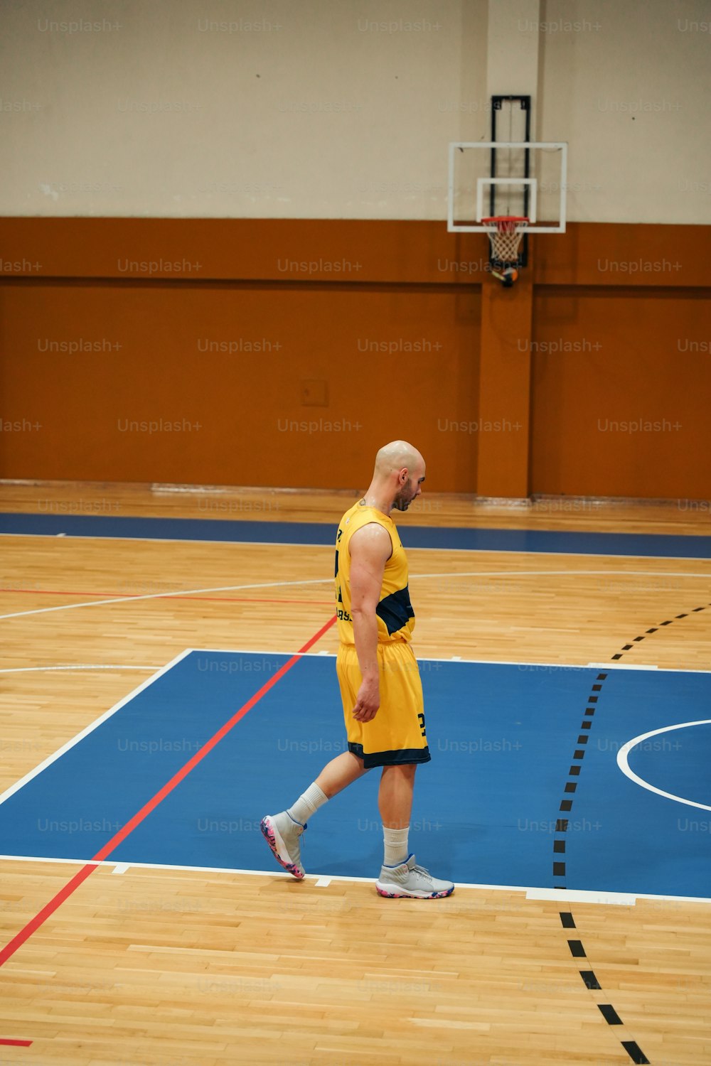 Un homme en uniforme jaune sur un terrain de basket