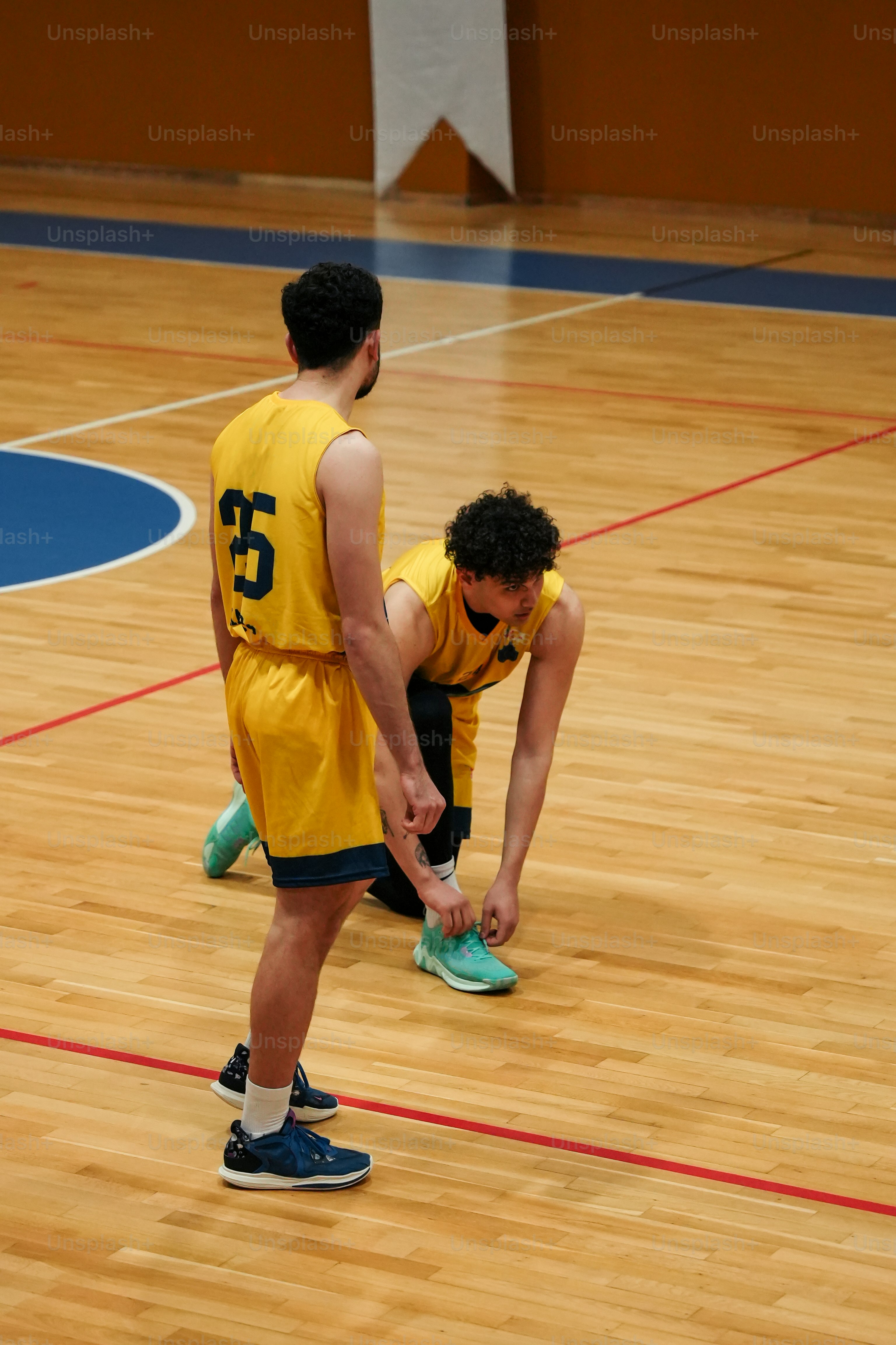 a man in a yellow uniform is holding a blue frisbee