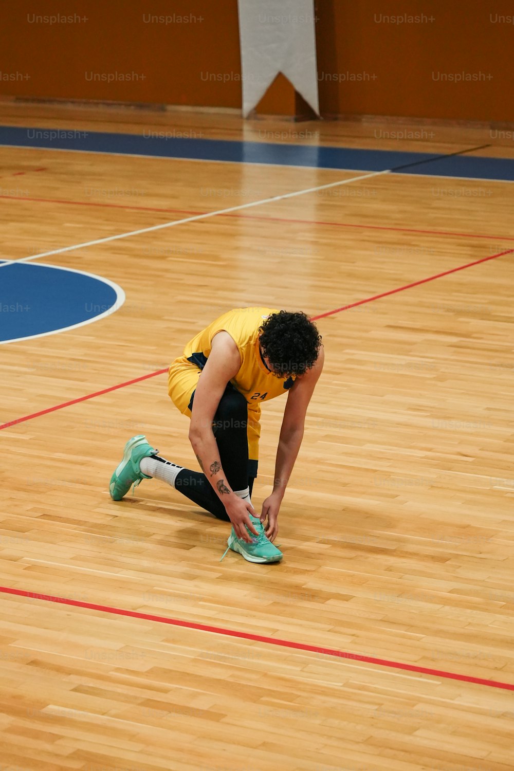 a person kneeling down on a basketball court