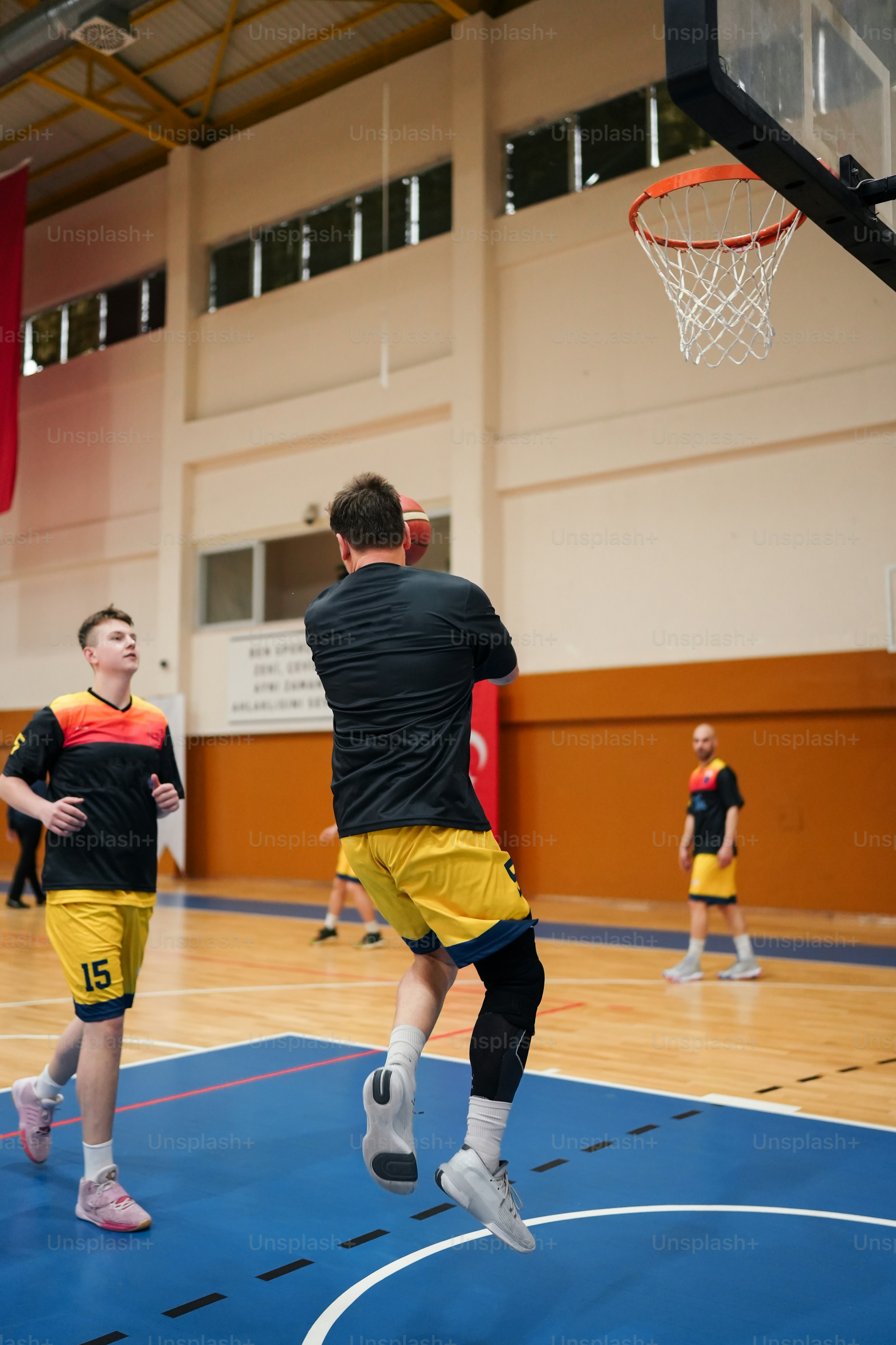 a group of young men playing a game of basketball