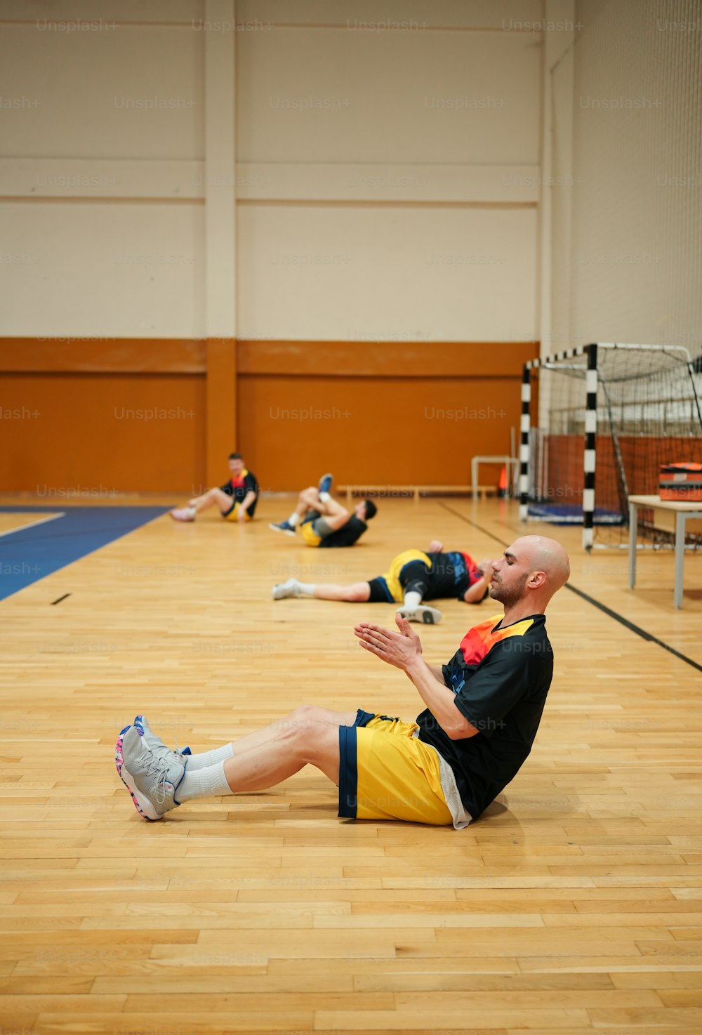Un hombre sentado en el suelo en un gimnasio