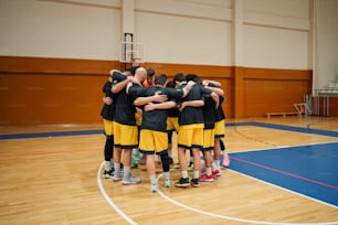 a group of young men standing on top of a basketball court