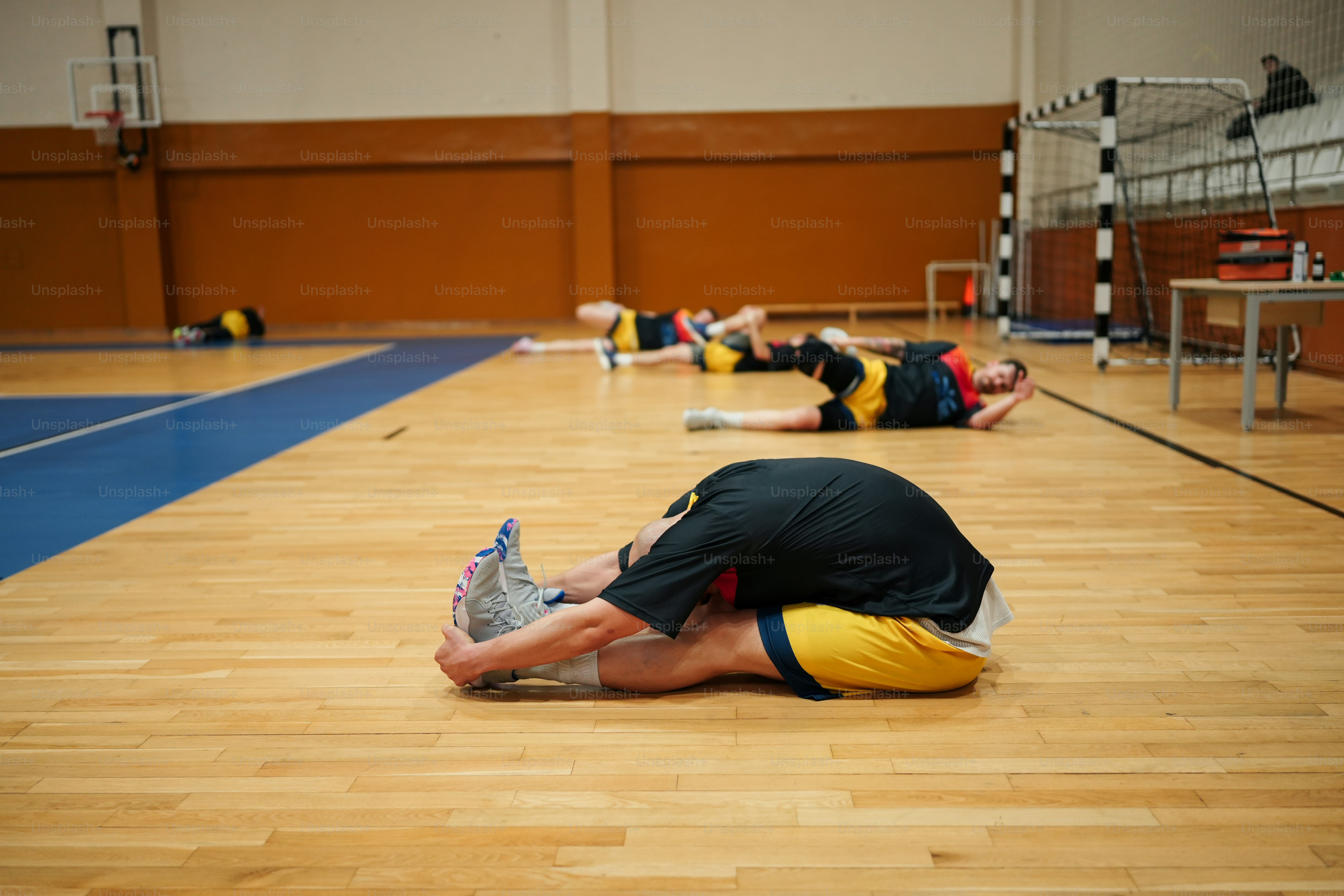 a group of people laying on the floor in a gym