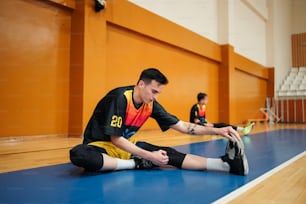 a man sitting on the floor in a gym