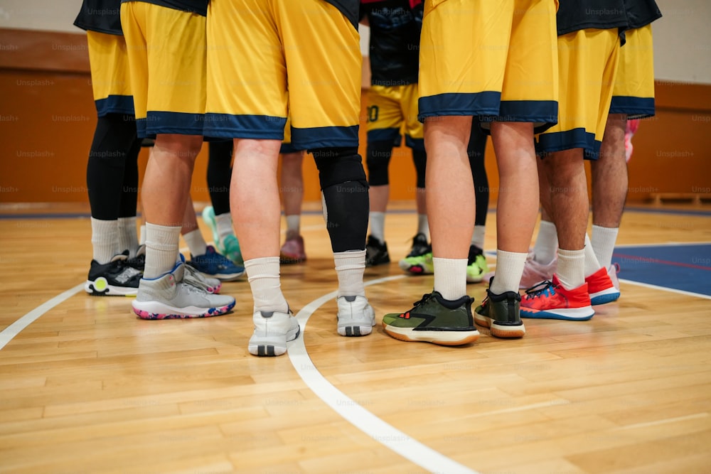 um grupo de homens em pé em cima de uma quadra de basquete