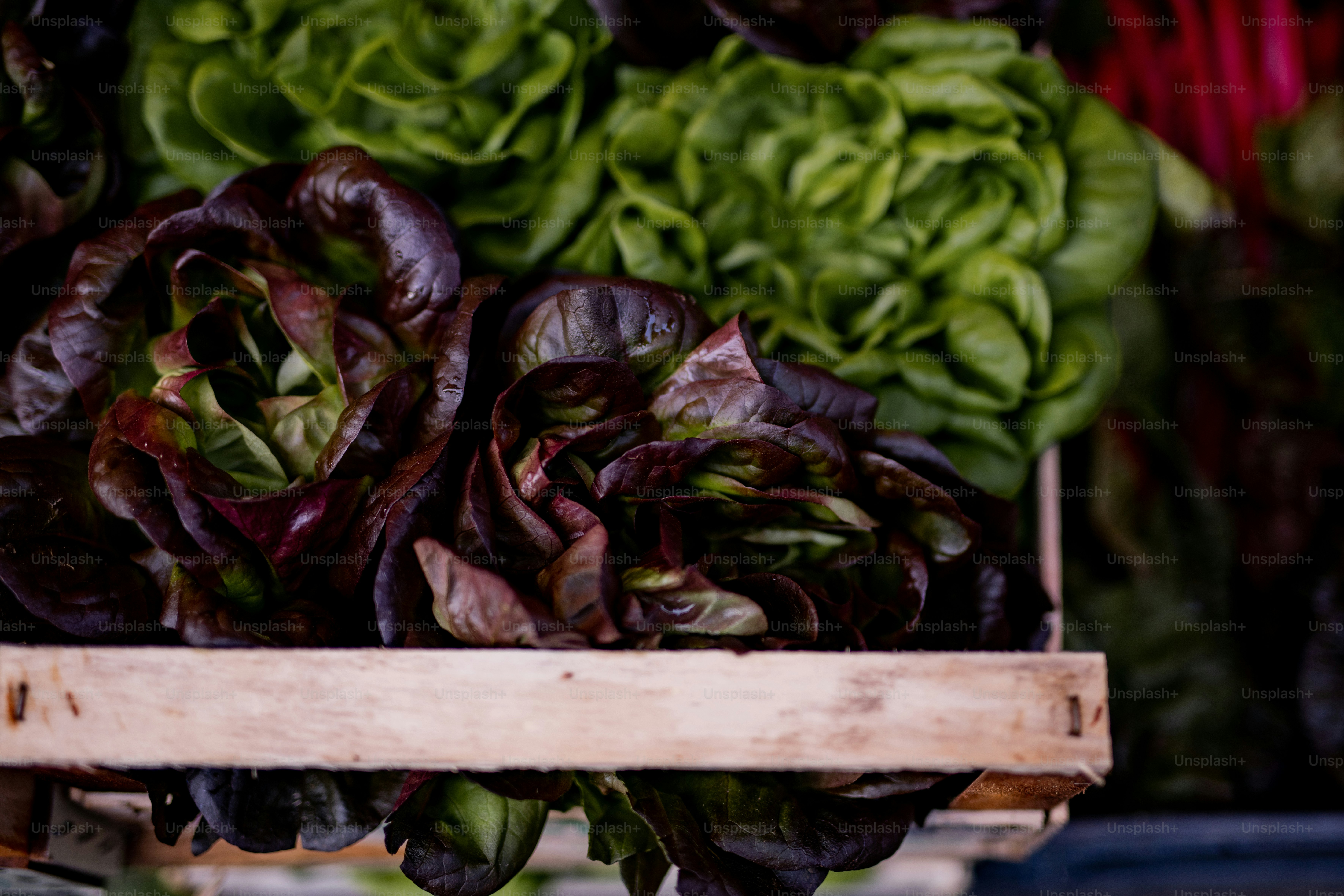 a pile of lettuce sitting on top of a wooden box