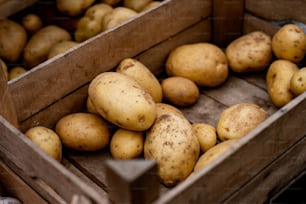 a wooden crate filled with lots of potatoes