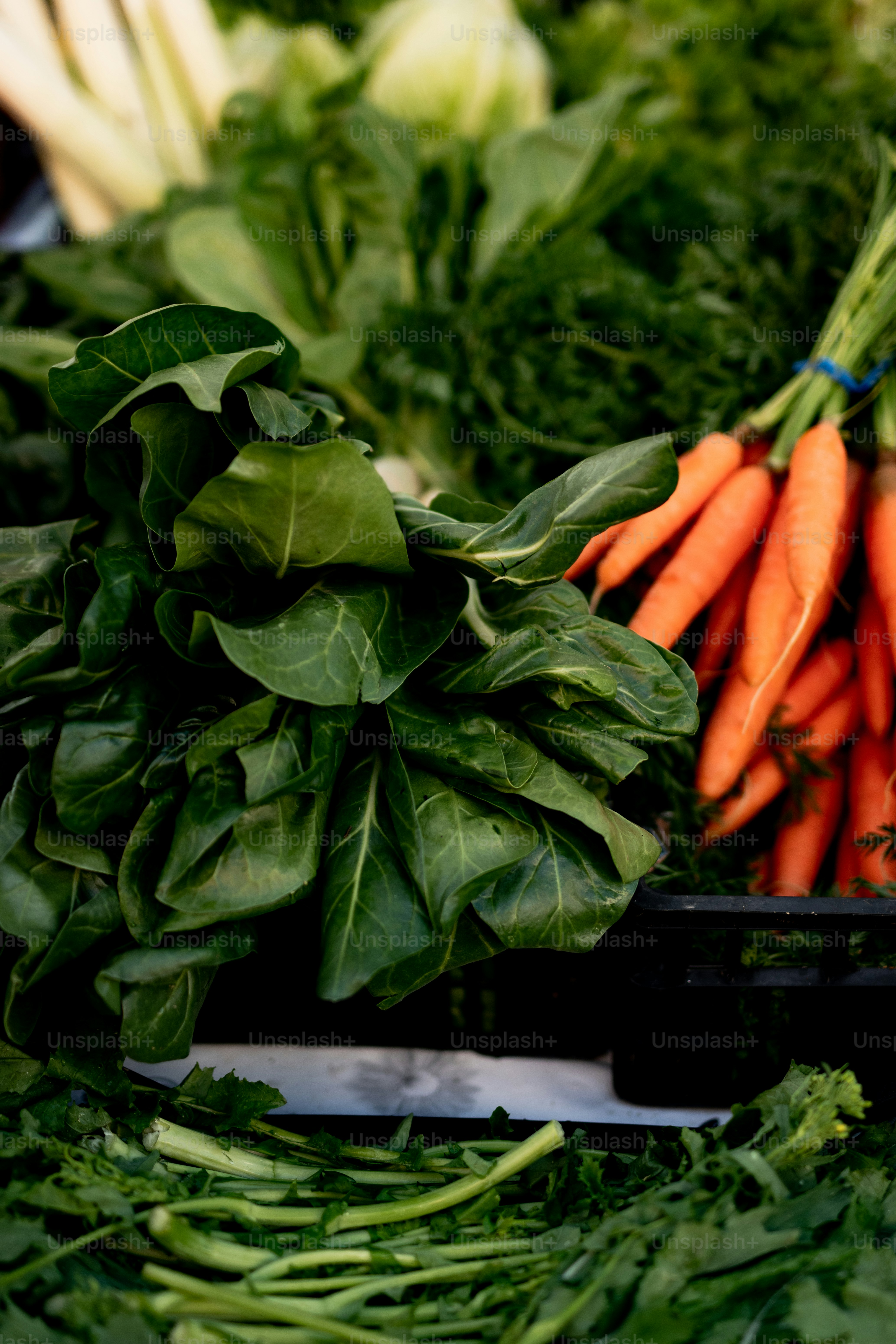 a pile of carrots and spinach on a table
