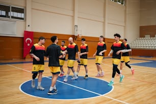 a group of men standing on top of a basketball court