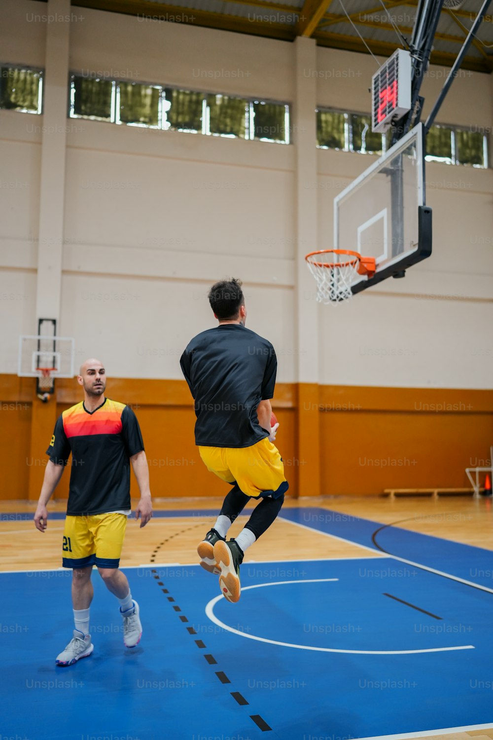 um homem pulando no ar para mergulhar uma bola de basquete