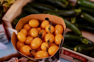 Una caja de cartón llena de muchos tomates