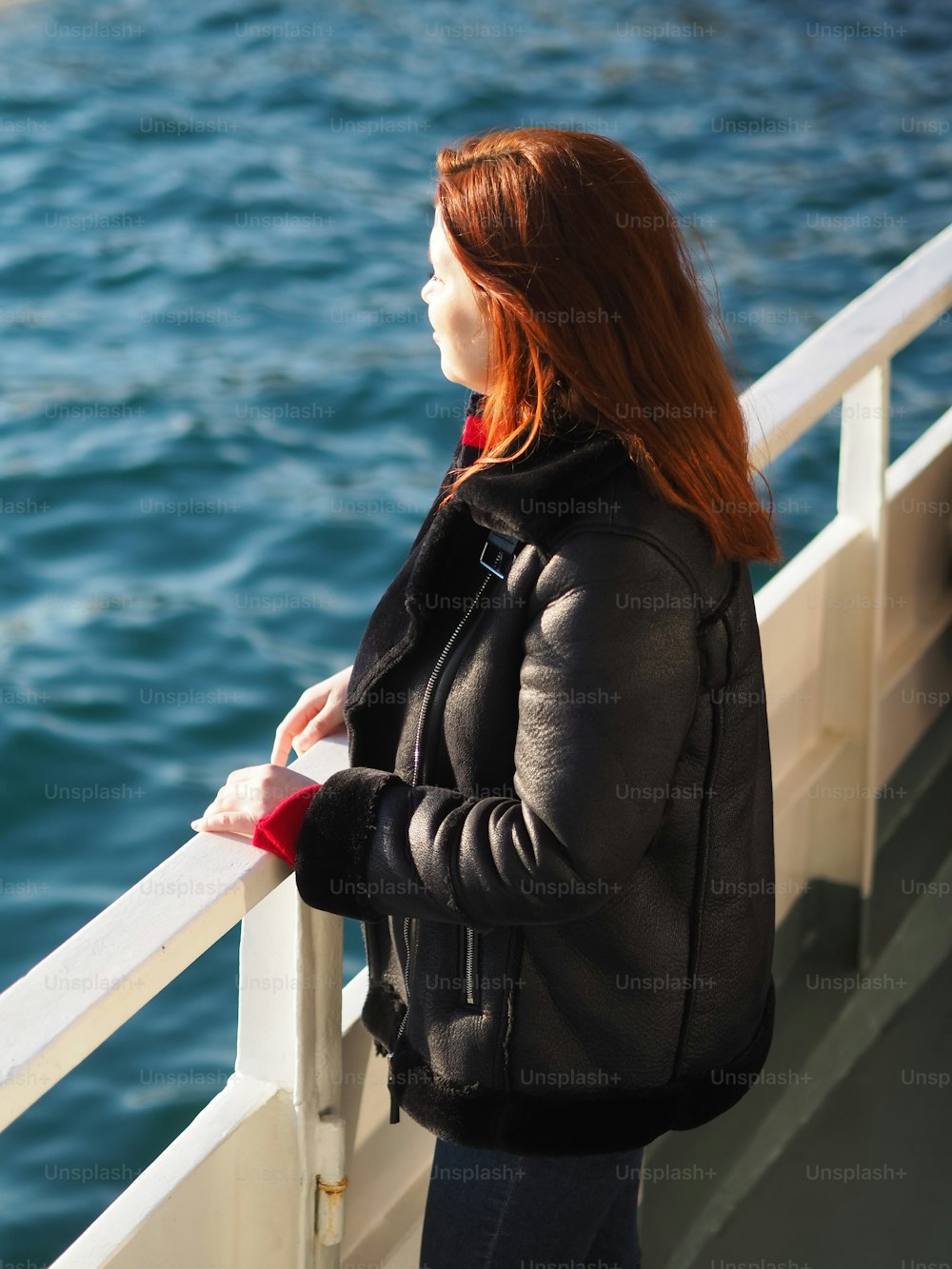 a woman standing on a boat looking at the water