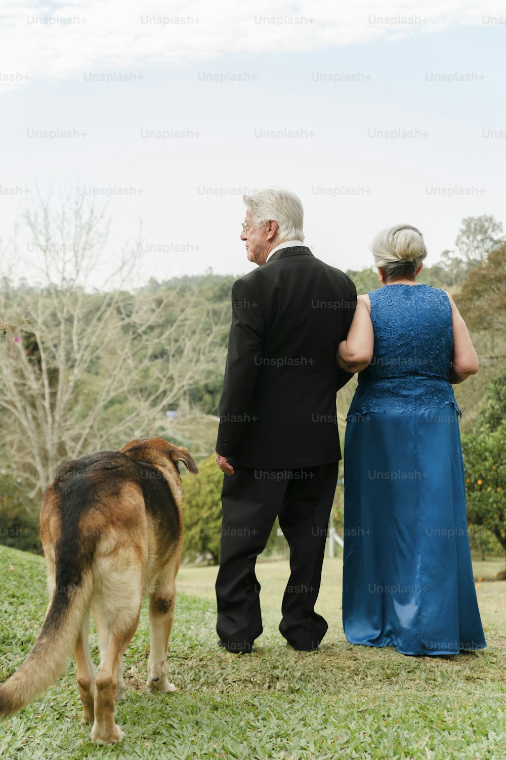a man and a woman standing next to a dog