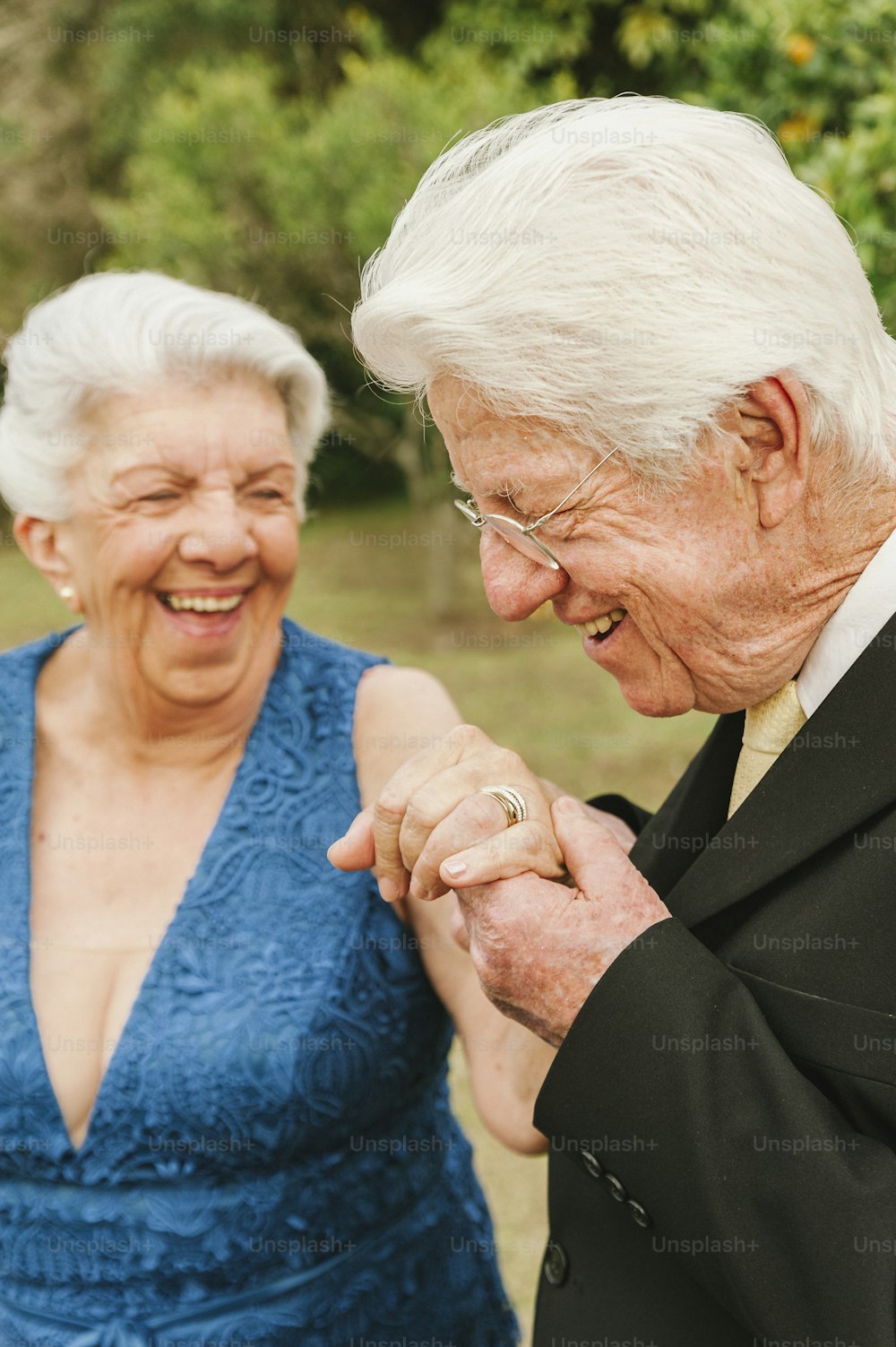 Ein älteres Paar, das Händchen hält und lächelt