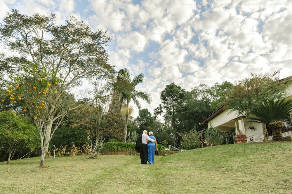 a couple of people standing on top of a lush green field