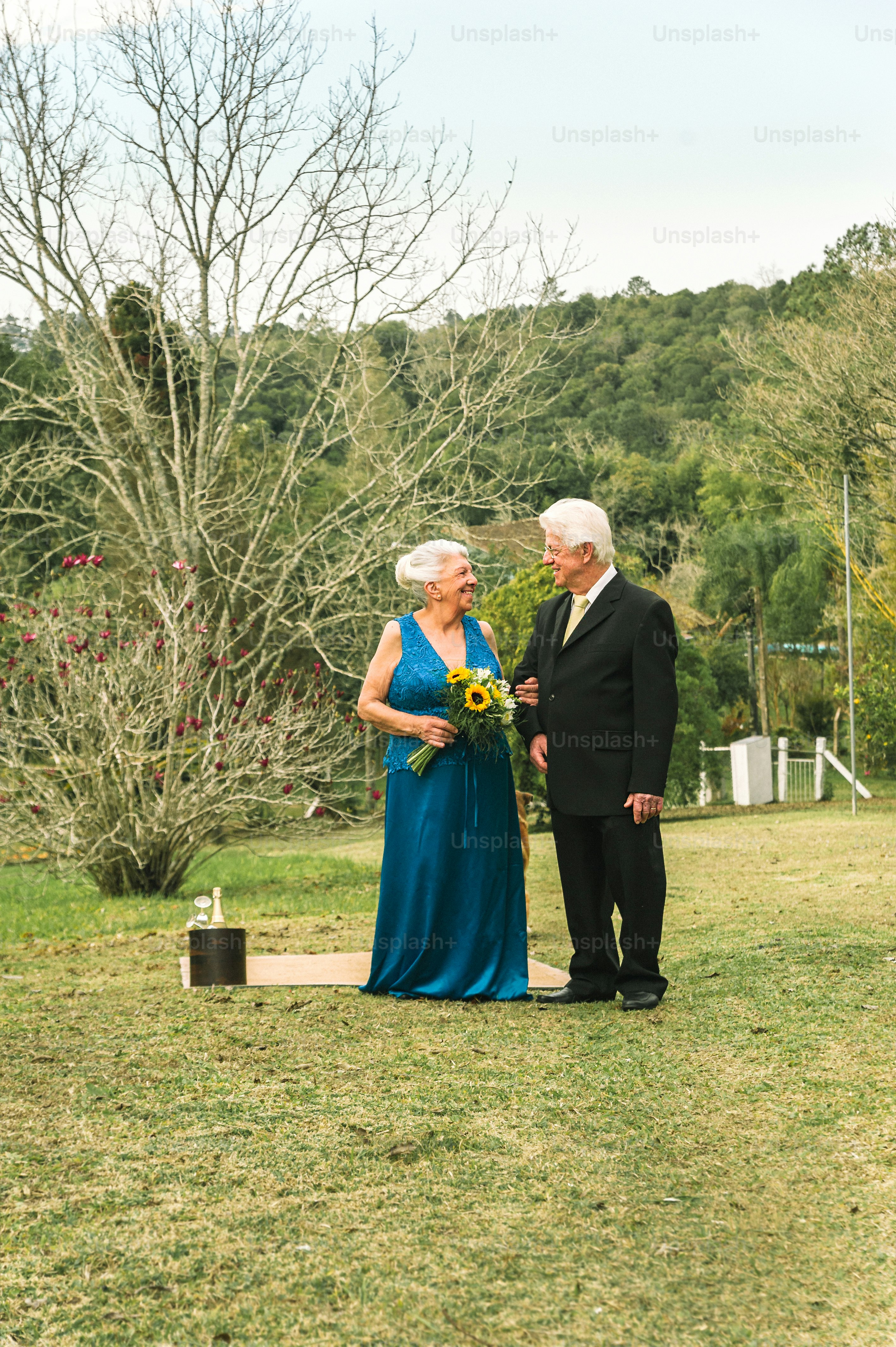 a man and woman standing next to each other in a field