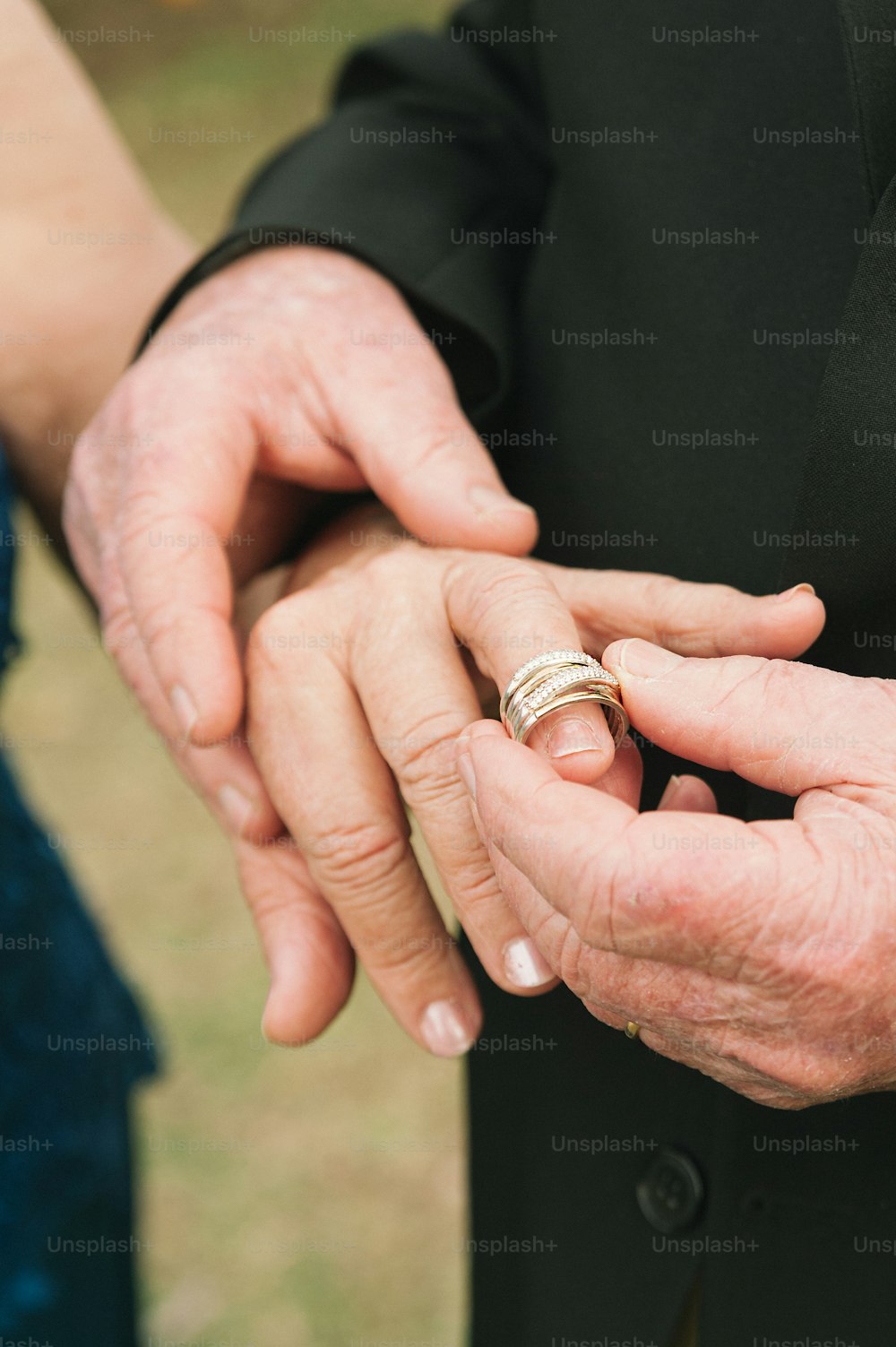 a close up of a person holding a wedding ring