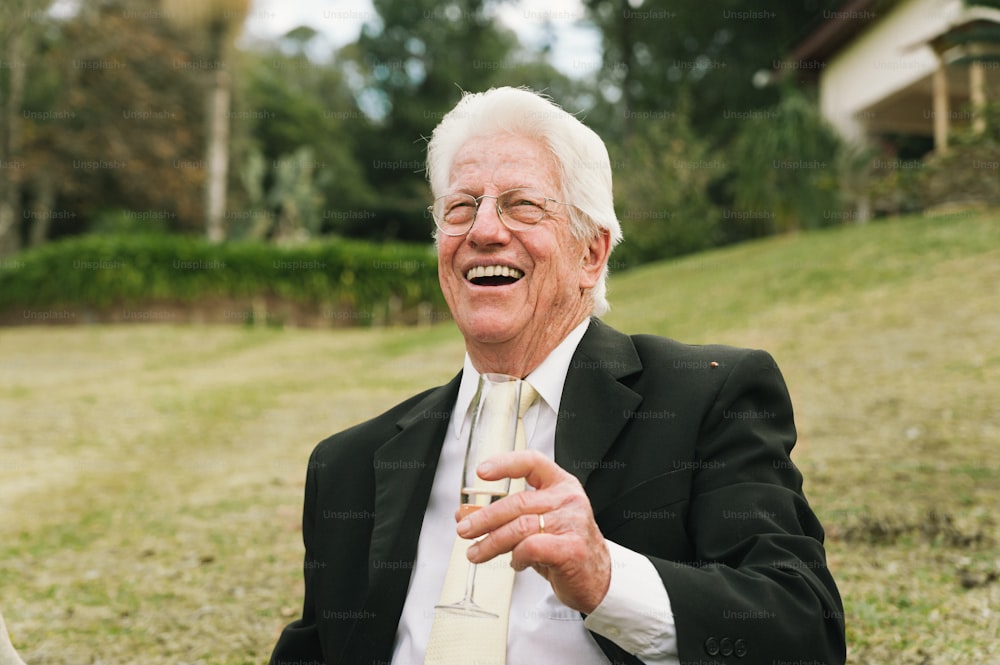 Ein älterer Mann in Anzug und Krawatte lacht