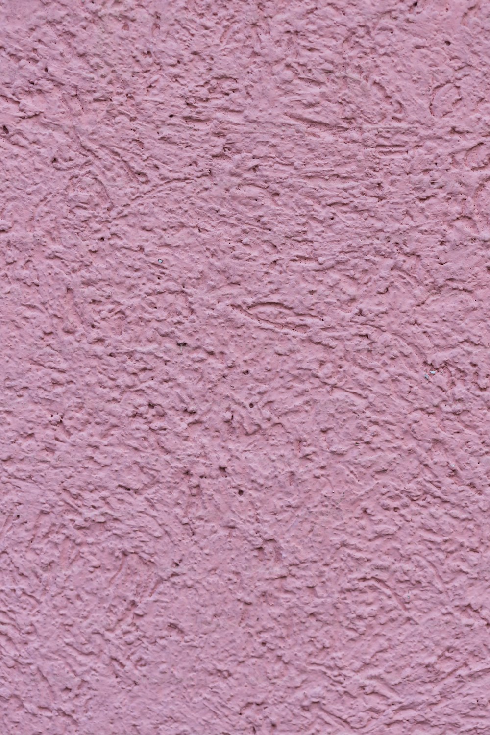 Un primo piano di una parete di stucco rosa