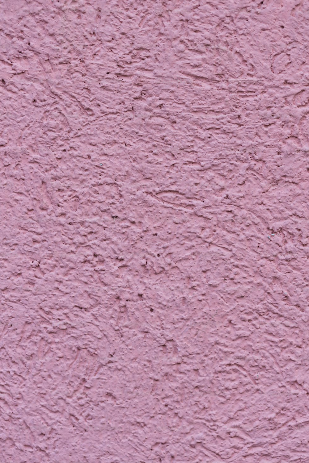 a close up of a pink stucco wall