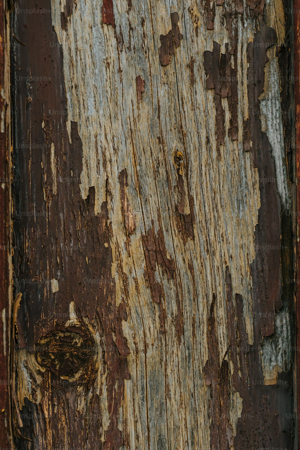 a close up of a wooden door with peeling paint