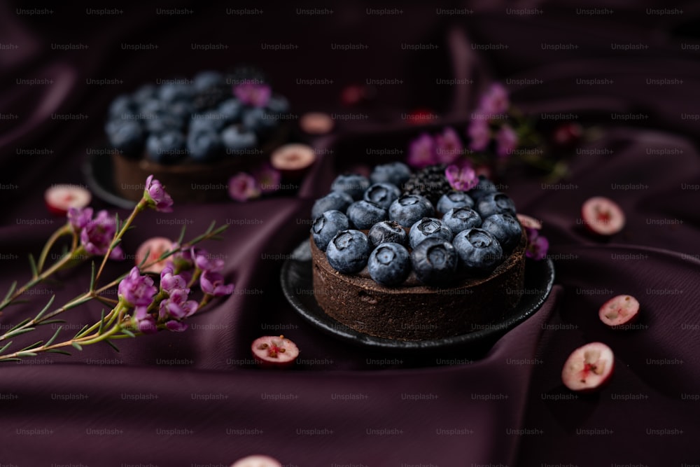 ein Schokoladenkuchen mit Blaubeeren und lila Blüten