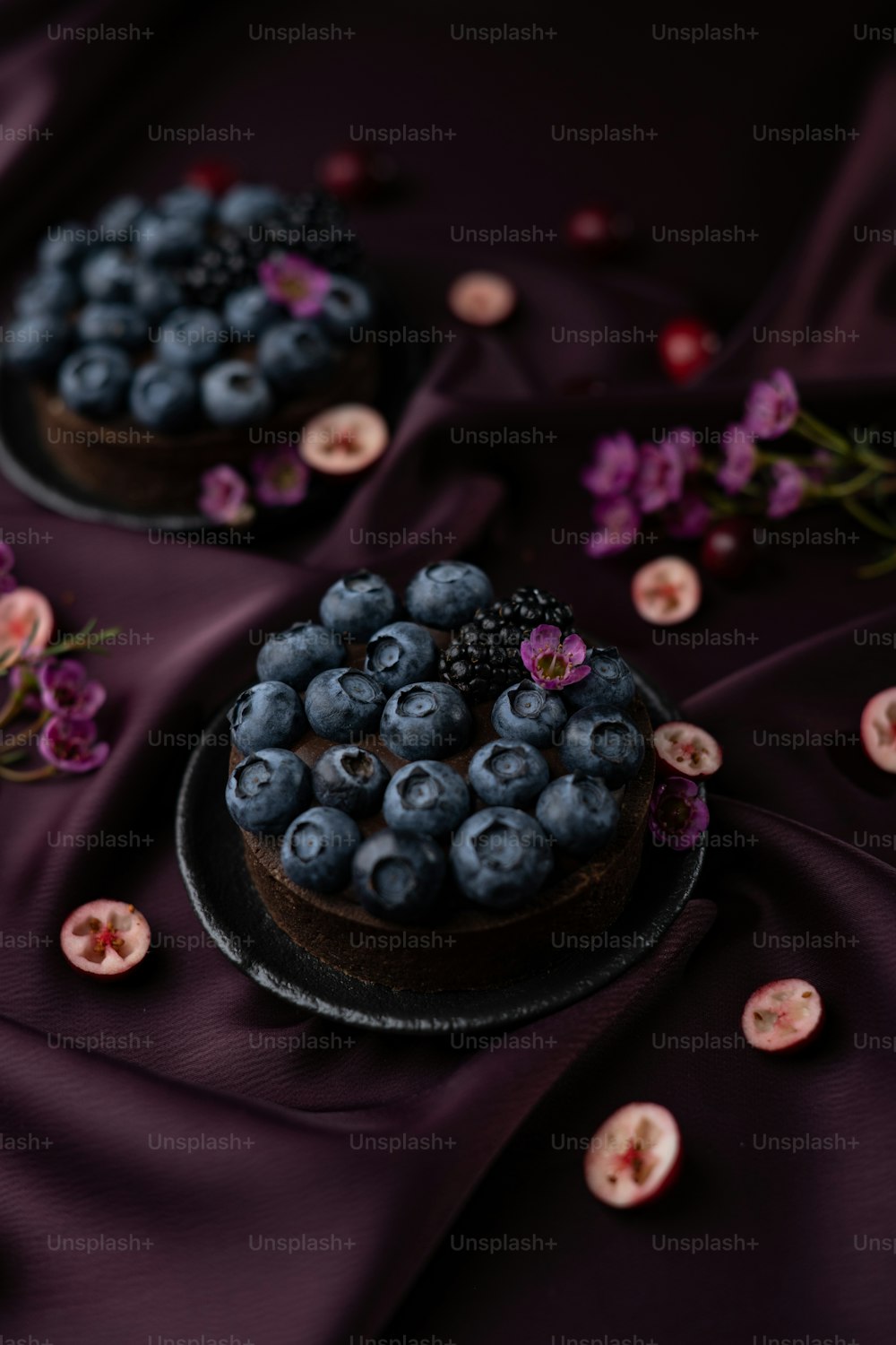 a chocolate cake topped with blueberries and flowers
