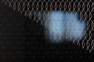 a blurry image of a television screen behind a mesh fence