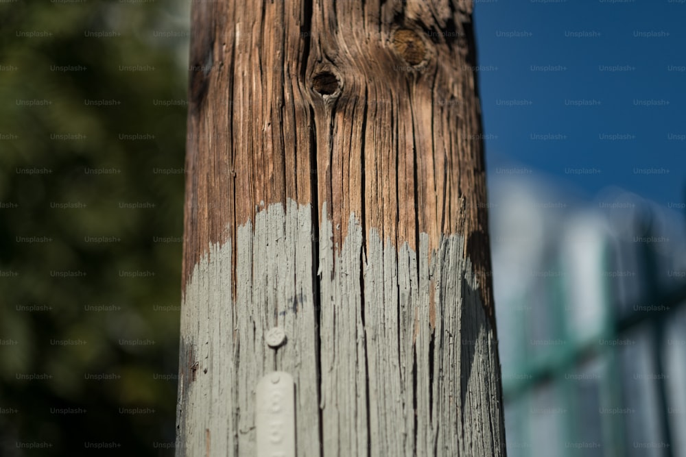 a close up of a telephone pole with a building in the background