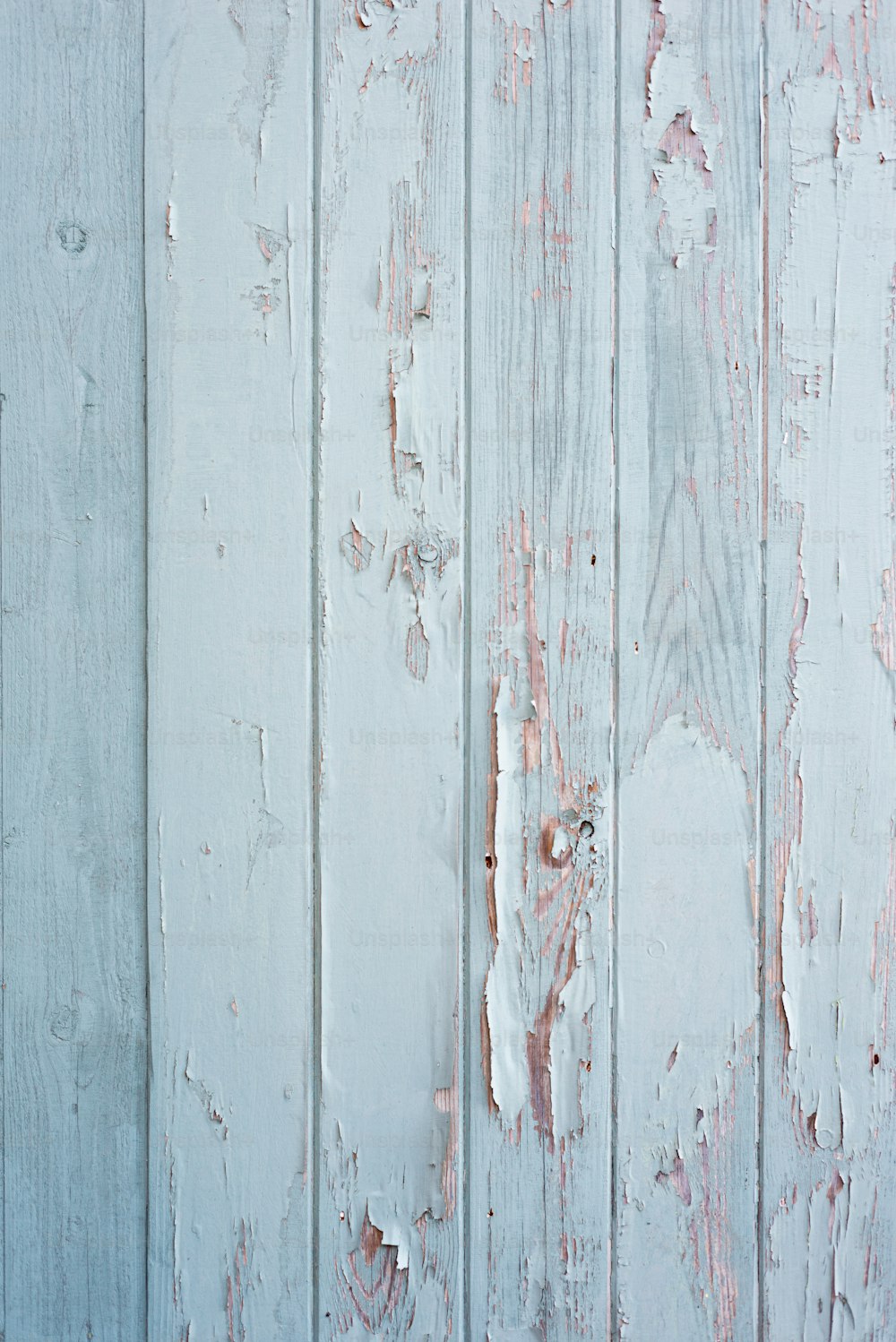 una parete di legno bianco con vernice scrostata su di esso
