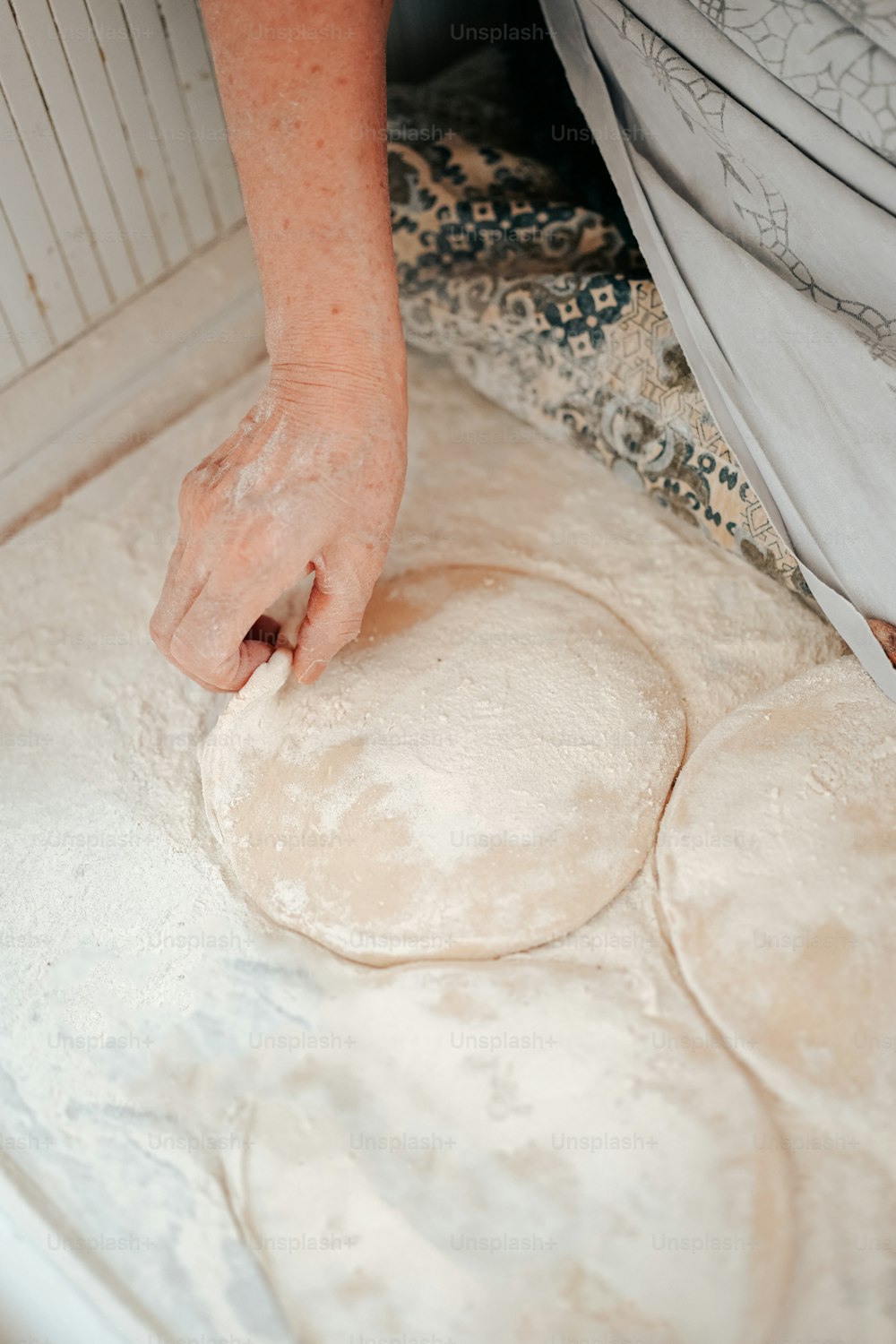 a person kneading dough on top of a table