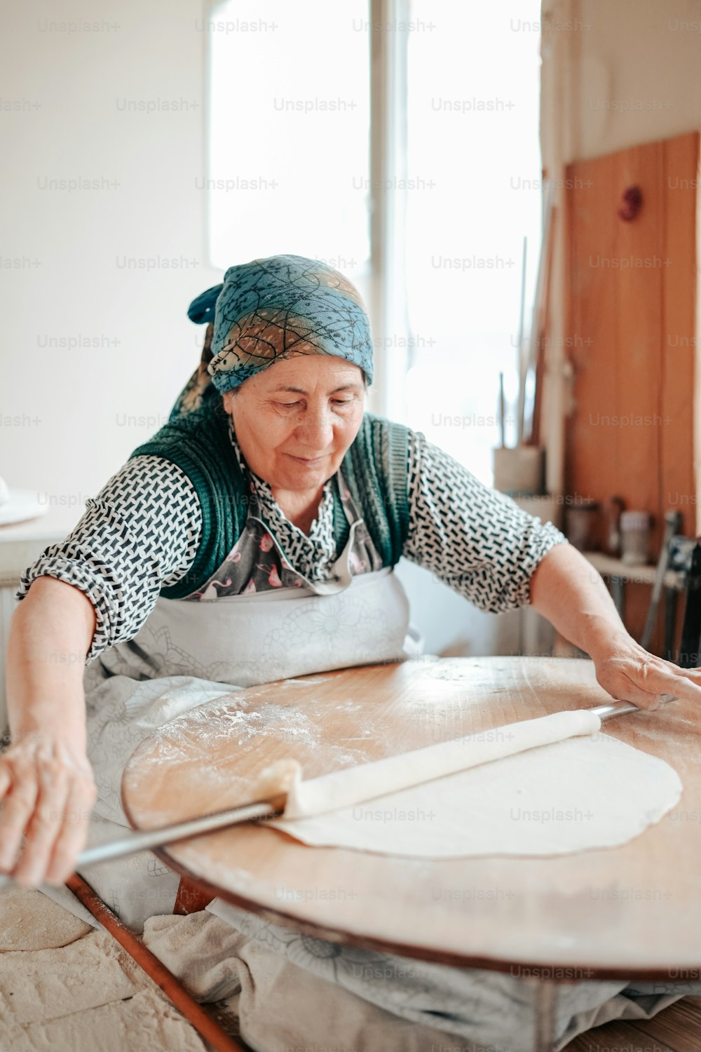 Una donna sta facendo il pane su un tavolo